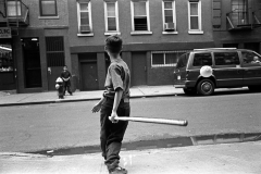 Boy playing baseball Mulberry Street, NYC 